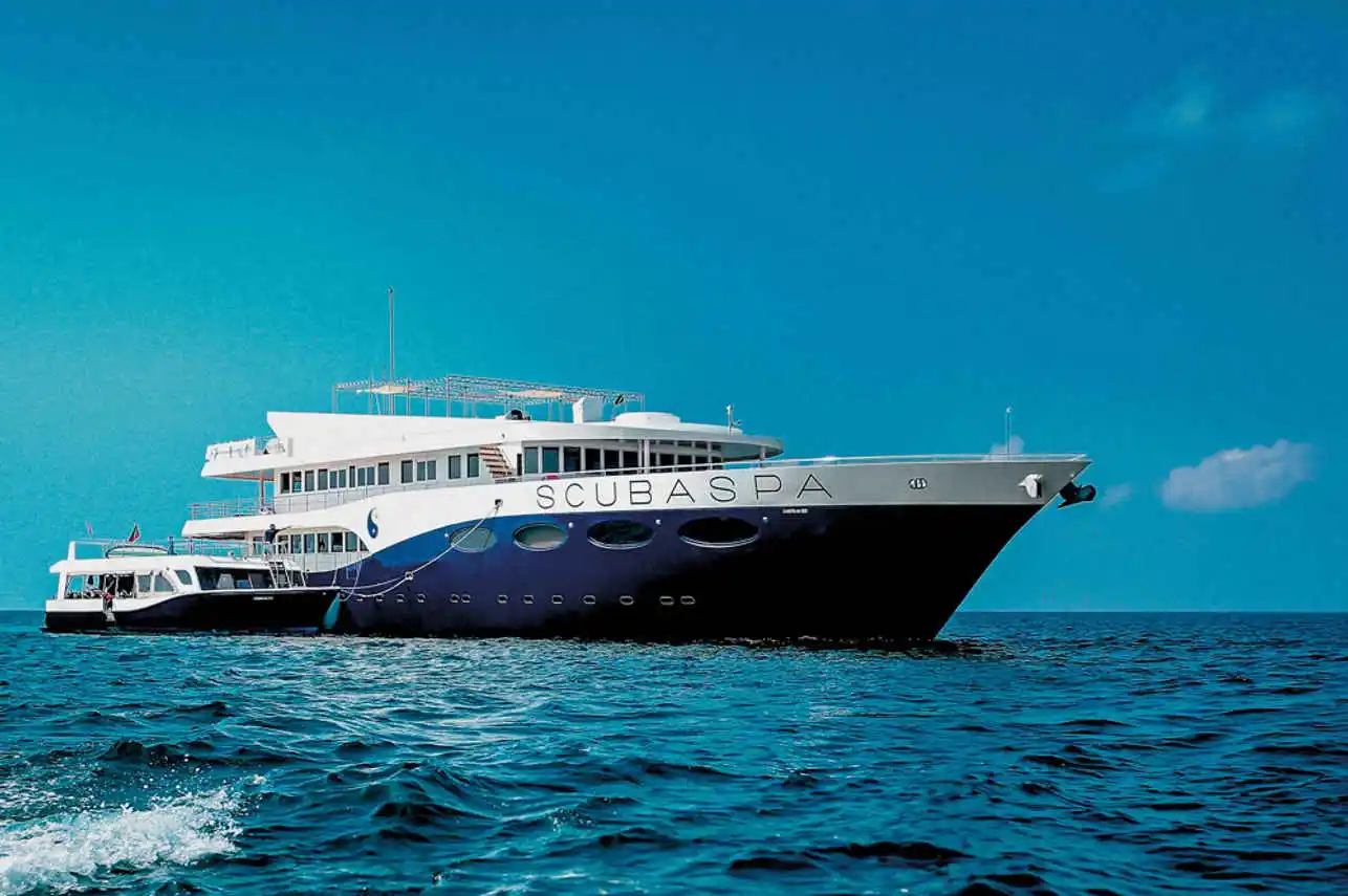 Scubaspa Ying 50-metre floating resort anchored over a shallow reef; spa deck and loungers visible.